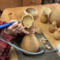 This shows me carving a vase rim into the top of a dried gourd.